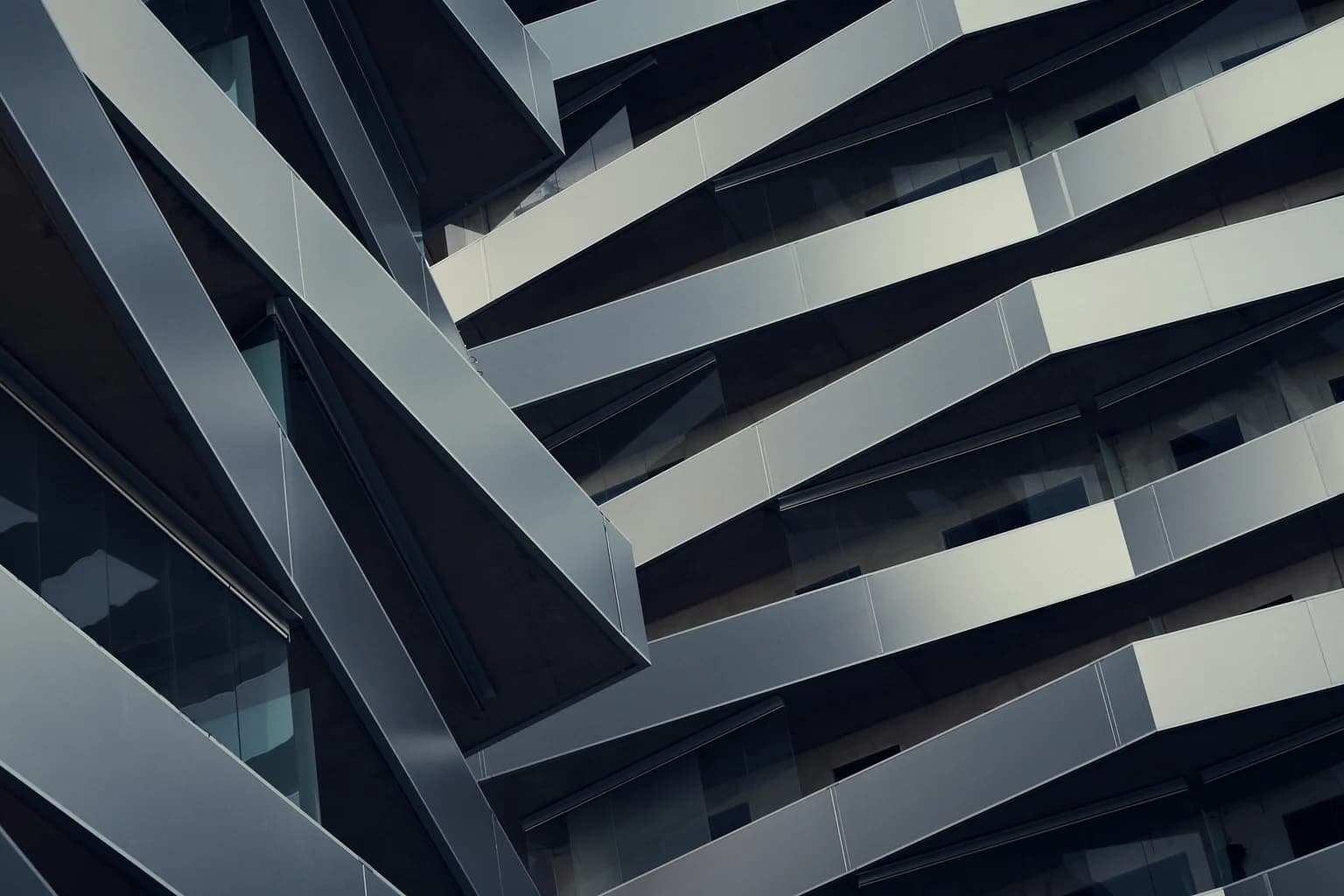 Repeating geometric layers cross the facade of a modern building.